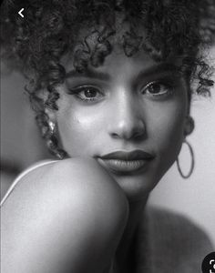 a black and white photo of a woman with curly hair