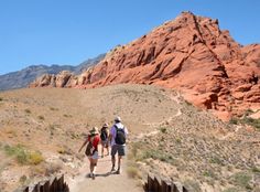 three people walking down a path in the desert