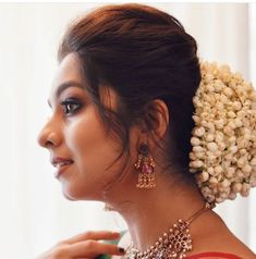 a woman in a red and white sari with pearls on her head, wearing jewelry