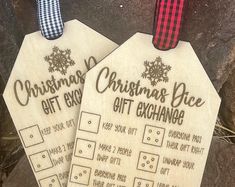 two wooden christmas gift tags sitting next to each other on top of a stone slab