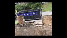 a dumpster sitting on the side of a road next to some rocks