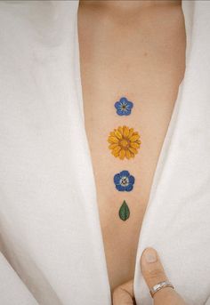 a woman's chest with three flowers on it