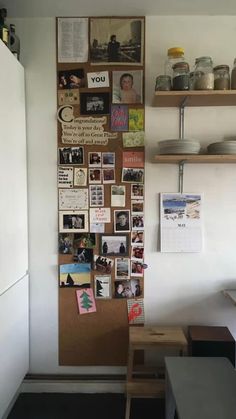 a kitchen wall with pictures and magnets on the back side, hanging from wooden shelves