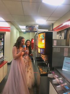 two women standing next to each other near a vending machine