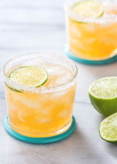 two glasses filled with lemonade and lime slices