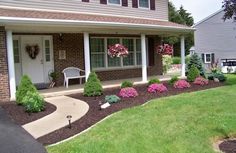 a house with flowers and bushes in the front yard