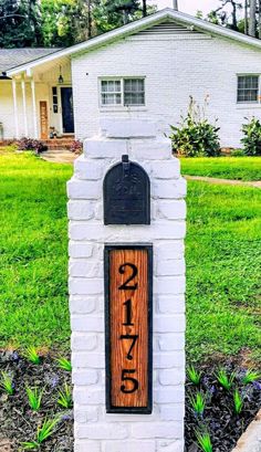 a white brick mailbox with the word spring written on it in front of a house