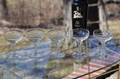 five wine glasses are lined up on a glass table