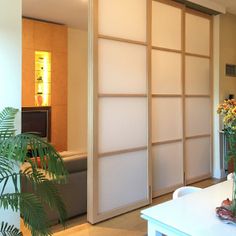 a living room filled with furniture and a sliding door that has frosted glass panels on it