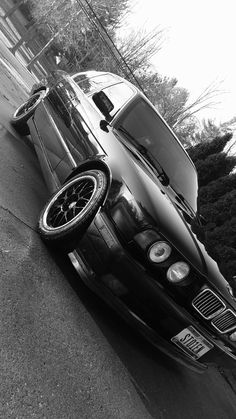 a black and white photo of a car parked on the street