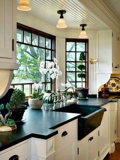 a kitchen filled with lots of counter top space next to two large windowed windows