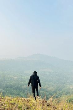 a man standing on top of a lush green hillside