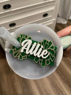 a person holding a toothbrush in a cup with the word alive on it and green leaves