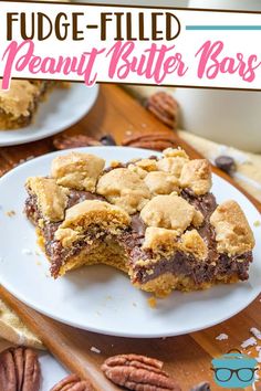 fudge - filled peanut butter bars on a white plate with pecans around it