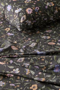 an image of a flowered bed sheet set on top of a pillow case with the cover pulled down