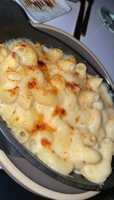 a pan filled with macaroni and cheese on top of a table