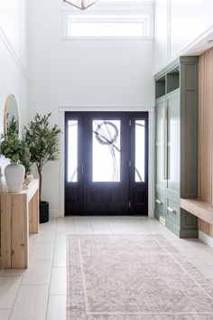 an entry way with a rug and potted plants