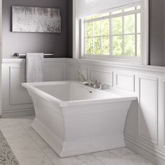 a white bath tub sitting next to a window