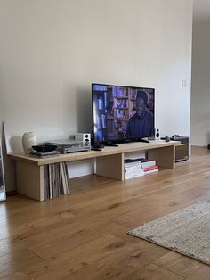 a flat screen tv sitting on top of a wooden shelf