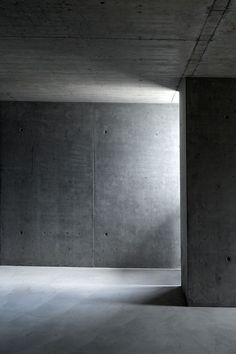 an empty room with concrete walls and floor