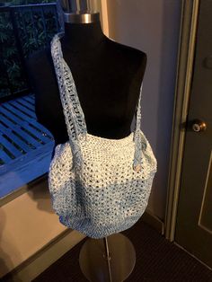 a crocheted bag sitting on top of a mannequin