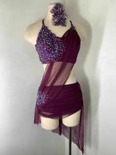 a mannequin wearing a purple dress with sequins on the top and bottom