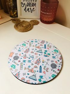 a white table topped with a round plate covered in cartoon pictures and writing on it