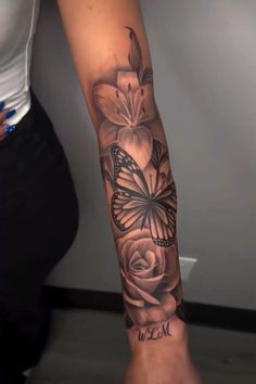 a woman's arm with flowers and a butterfly on it