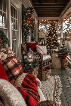 the porch is decorated for christmas with plaid blankets and pillows on it's couches