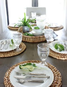 the table is set with silverware, plates and utensils in wicker baskets