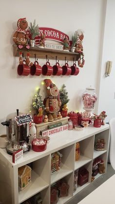 a shelf filled with lots of different types of christmas decorations on top of white shelves