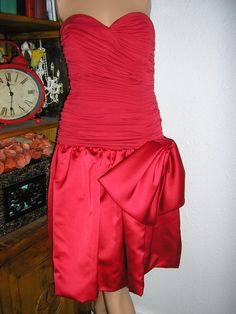 "Vintage 70s, red silk and satin strapless formal cocktail dress. By Morton Myles for the Warrens, Saks Fifth Avenue. Back zip. Large side bow, ruched top, dropped waist. Sides of bodice are boned. Red union label. Lined. Excellent condition, no flaws or damage. Measurements: chest across front: 16\" waist (natural) across front: 12\" hips across front: 16\" length: (from armpit) 34\" plus 1\" hem Please read all measurements and view all photos provided before purchasing as I do NOT accept retu Party Strapless Dress With Satin Bow, Evening Strapless Satin Dress With Bow, Strapless Prom Dress With Satin Bow, Strapless Dress With Satin Bow For Prom, Formal Fitted Strapless Dress With Satin Bow, Strapless Evening Dress With Bow For Cocktail, Red Satin Strapless Dress For Prom, Red Satin Strapless Evening Dress, Red Satin Strapless Dress For Evening