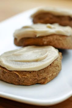 two cookies with icing sitting on a white plate