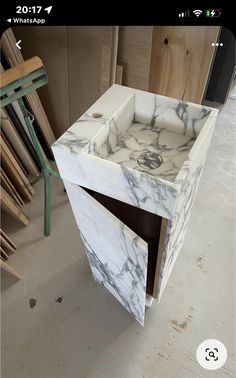 a white marble sink sitting on top of a wooden table