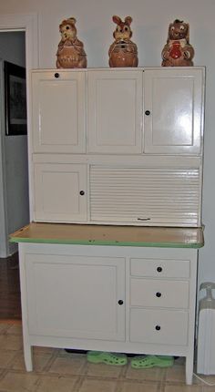 three teddy bears sitting on top of a white cabinet