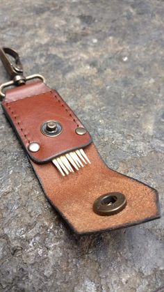 a brown leather keychain with a button on it