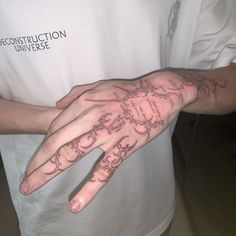 a person with a tattoo on their hand holding something in the other hand that has writing all over it