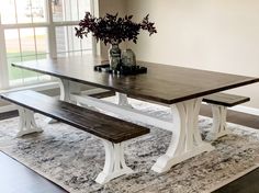 a table with two benches in front of it and a vase full of flowers on top