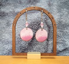 Beautiful, handmade, enamel round shape dangle earrings with stainless-steel wires. White and pink enamel combine nicely to create exquisite earrings! Gorgeous pink and white glass beads add to the earrings charm! Stainless-steel fishhook ear wires make these earrings hypoallergenic.  Handmade in Juneau, Alaska by a lifelong Alaskan.  Designed using a copper base, lead-free enamel powder is used to carefully coat both sides, heating the piece until the enamel formed a smooth, glass surface. Once fired, the enamel creates brilliant and long-lasting colors. The earrings are 26 mm in diameter. Various photographs are provided to give the buyer an idea of how the earrings look in different light.  Each piece is handmade, and you will see there are slight differences between the two earrings. T Handmade Pink Metal Earrings, Hand Painted Pink Round Earrings, Pink Hypoallergenic Round Earrings, Hypoallergenic Pink Round Earrings, Pink Circular Nickel-free Jewelry, Pink Drop Earrings With French Hook, Handmade Pink Circular Earrings, Handmade Pink Circle Earrings, Pink Hand Painted Dangle Earrings