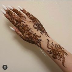 a woman's hand with henna tattoos on it