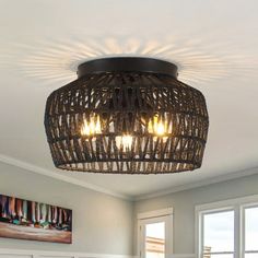 a bed room with a neatly made bed and a basket light hanging from the ceiling