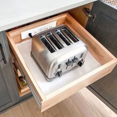 a toaster sitting on top of a wooden drawer