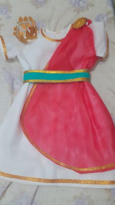 a dress made out of tissue paper with gold trimmings and a blue ribbon around the waist