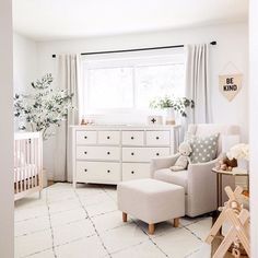 a baby's room with white furniture and decor