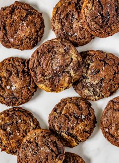 chocolate chip cookies are arranged on a white surface