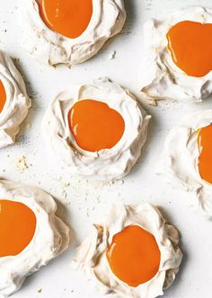 several cookies covered in white frosting and orange sauce