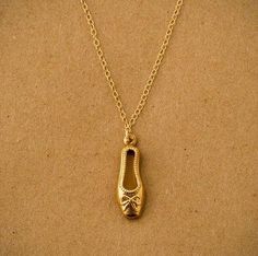 a gold necklace with a shoe on it