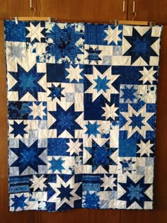 a blue and white quilt hanging on a wall