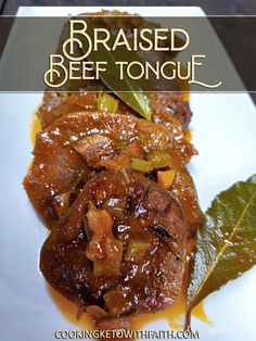 a close up of a plate of food on a table with text overlay that reads, raised beef tongue