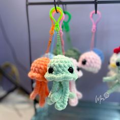 small crocheted toys hanging from hooks in a room with other items on the wall